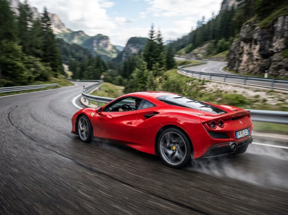 A red sports car speeding around a mountain road